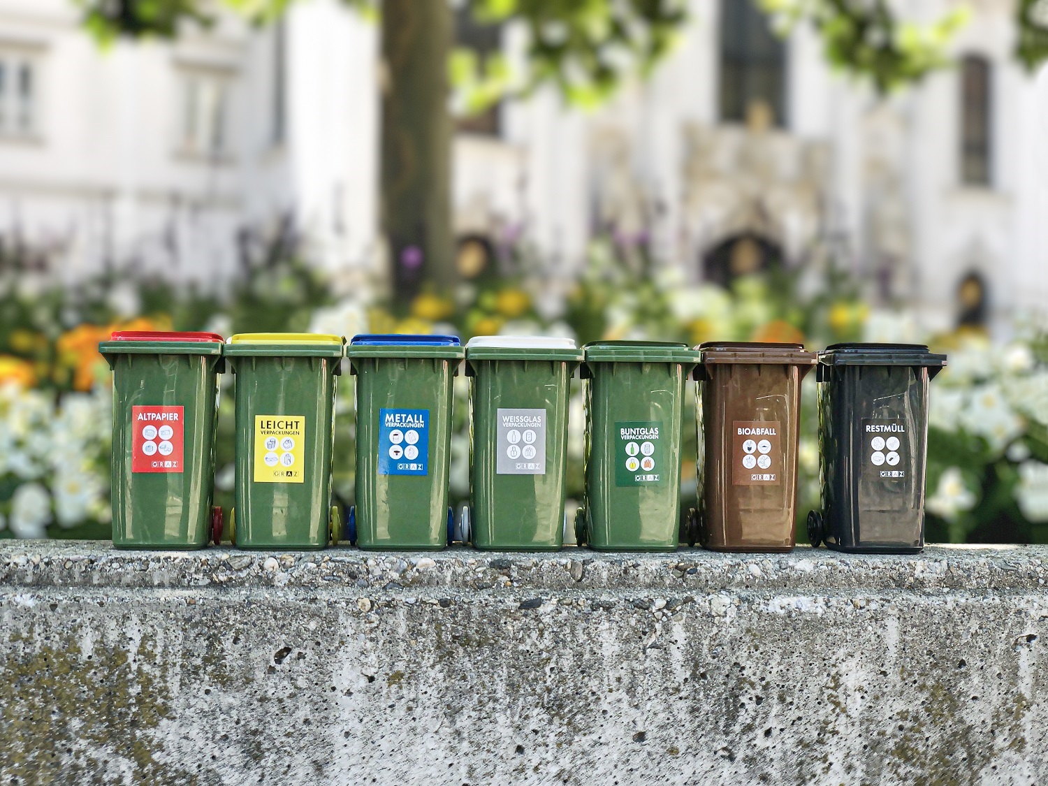 Miniature models of different garbage cans stand next to each other